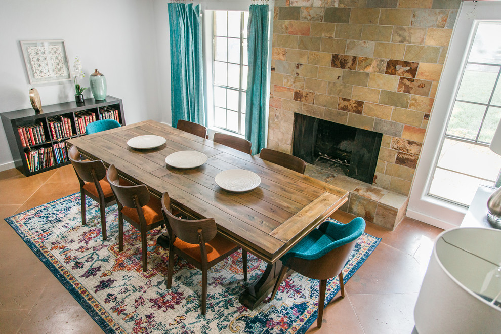 Imagen de comedor de cocina retro de tamaño medio con paredes azules, suelo de cemento, todas las chimeneas, marco de chimenea de piedra y suelo marrón