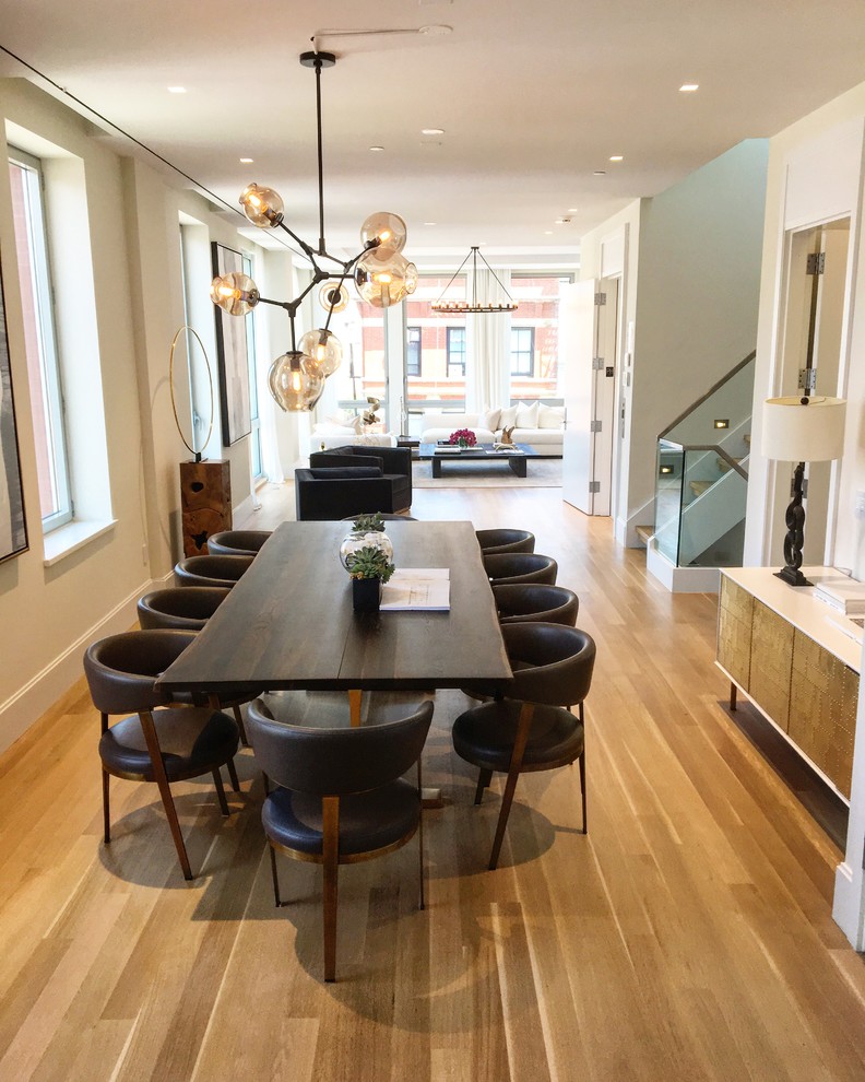 Example of a large minimalist light wood floor and beige floor kitchen/dining room combo design in New York with beige walls