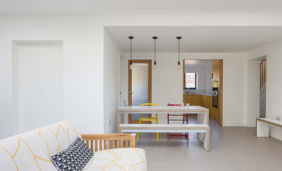 Idee per una sala da pranzo aperta verso il soggiorno minimal di medie dimensioni con pareti bianche, pavimento con piastrelle in ceramica e pavimento grigio