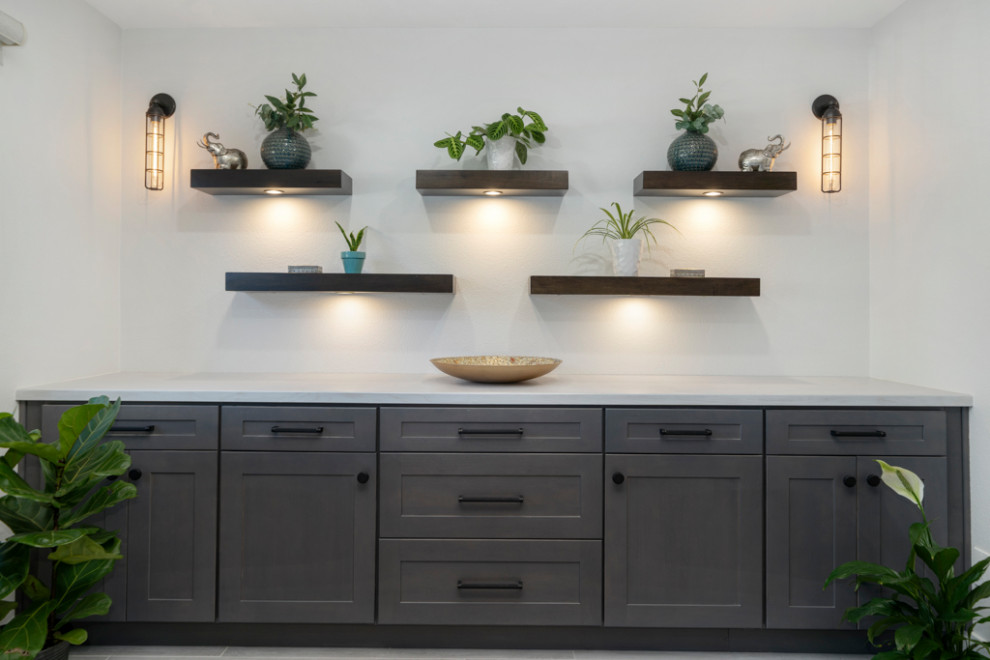 Источник вдохновения для домашнего уюта: кухня-столовая среднего размера в стиле модернизм с серыми стенами, полом из ламината, фасадом камина из камня и серым полом