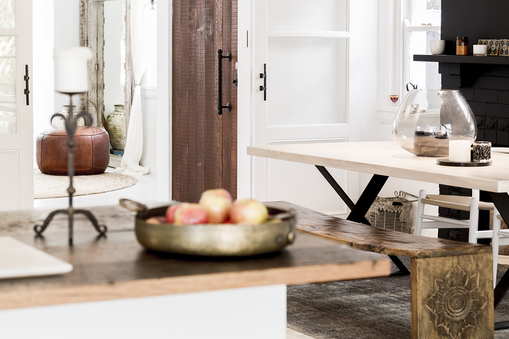 Inspiration för ett mellanstort minimalistiskt kök med matplats, med vita väggar, kalkstensgolv, en öppen vedspis och en spiselkrans i tegelsten