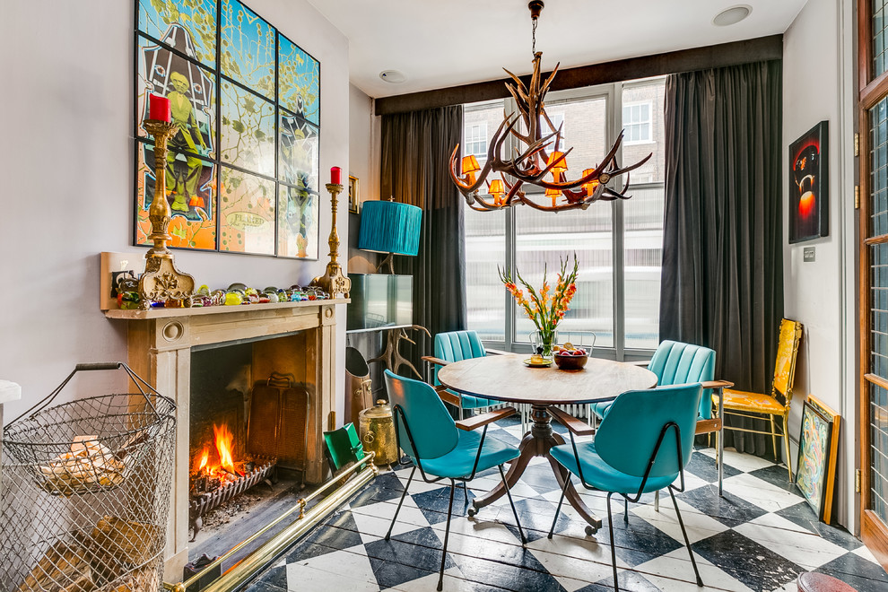 Dining room - mid-sized eclectic multicolored floor and painted wood floor dining room idea in London with gray walls and a standard fireplace