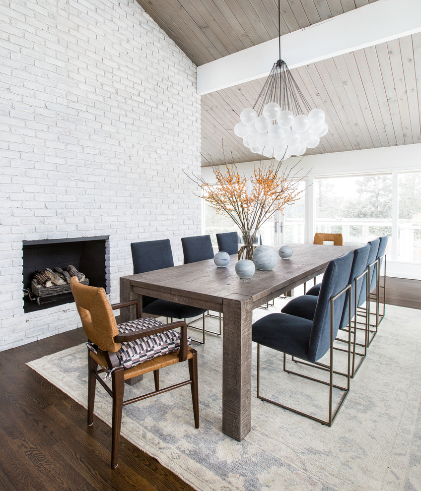Design ideas for a classic open plan dining room in Seattle with white walls, dark hardwood flooring, a standard fireplace and a brick fireplace surround.