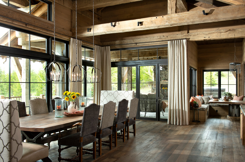 Foto di un'ampia sala da pranzo aperta verso la cucina stile rurale con pareti marroni, pavimento marrone e parquet scuro