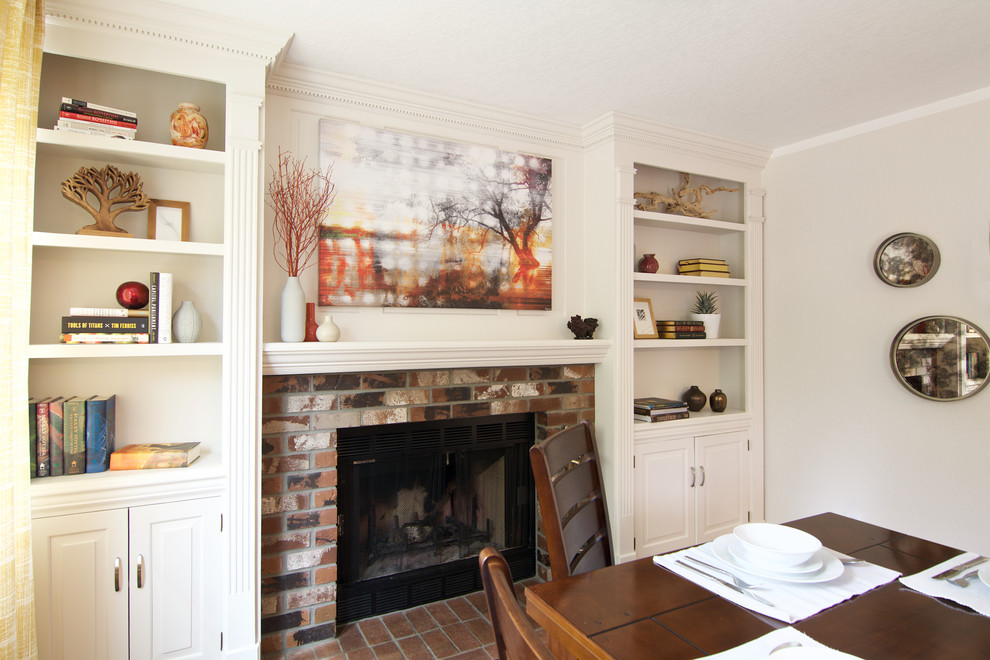 Aménagement d'une salle à manger classique fermée et de taille moyenne avec un mur blanc, sol en stratifié, une cheminée standard, un manteau de cheminée en brique et un sol marron.