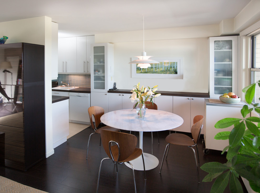 На фото: кухня-столовая в стиле ретро с белыми стенами и темным паркетным полом с