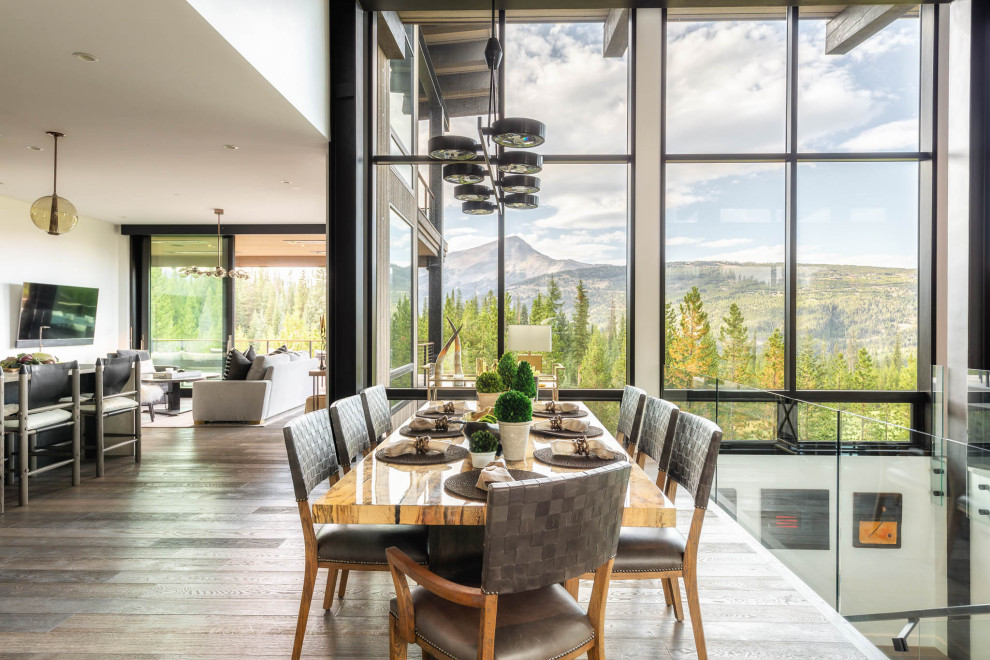 Immagine di una grande sala da pranzo aperta verso il soggiorno stile rurale con pavimento marrone e pavimento in legno massello medio