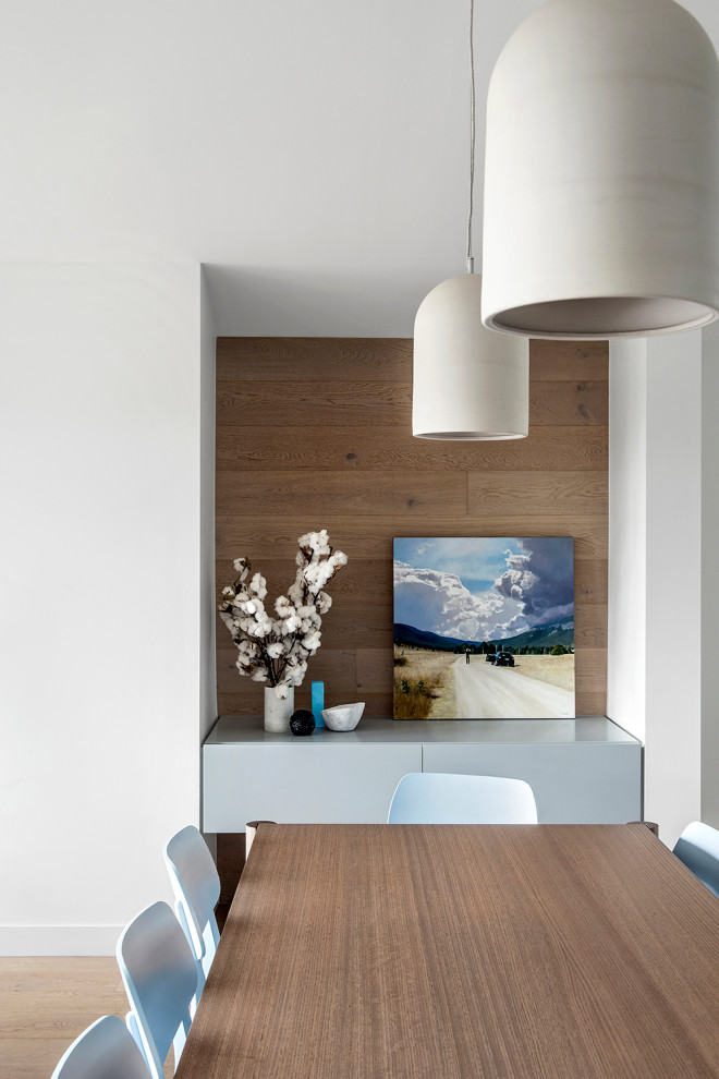 Imagen de comedor actual grande abierto con paredes blancas y suelo de madera clara