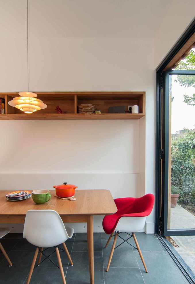 Foto di una sala da pranzo aperta verso la cucina design di medie dimensioni con pareti bianche, pavimento in ardesia e nessun camino