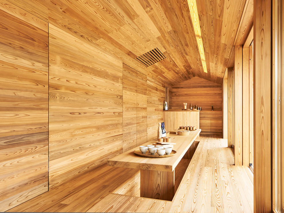 Cette photo montre une salle à manger asiatique avec un mur marron, un sol en bois brun, aucune cheminée et un sol marron.