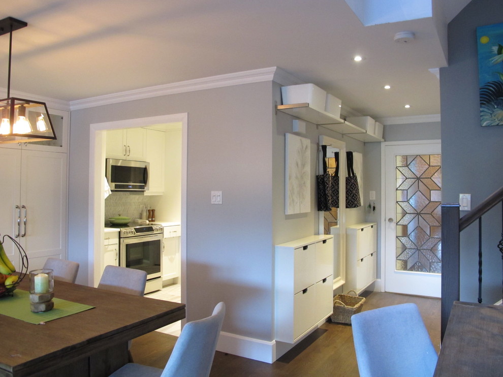 Cette photo montre une salle à manger ouverte sur la cuisine tendance de taille moyenne avec un mur gris, parquet foncé et un sol marron.