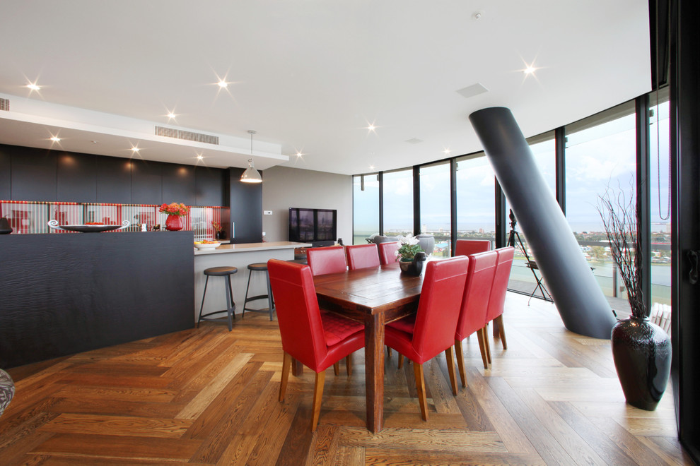 Foto di una sala da pranzo aperta verso la cucina minimalista con pareti grigie e pavimento in legno massello medio