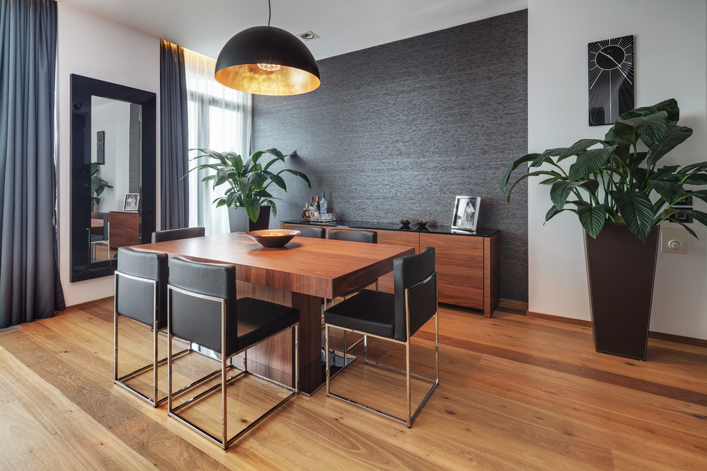 Réalisation d'une salle à manger design avec un mur noir et un sol en bois brun.