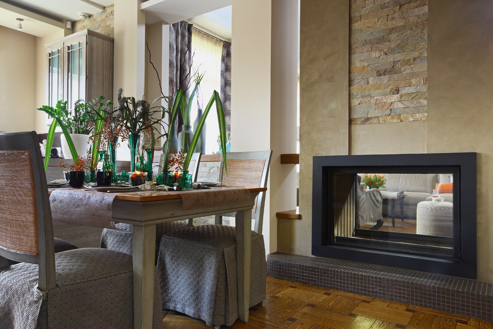 Imagen de comedor de cocina contemporáneo con paredes beige, suelo de madera en tonos medios y chimenea de doble cara
