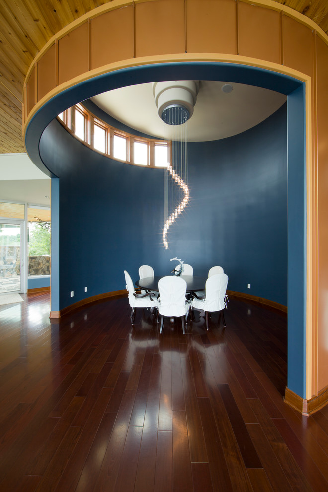 Immagine di una sala da pranzo design con pareti blu e parquet scuro