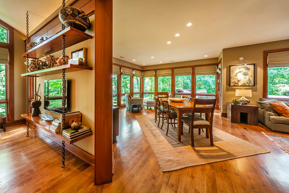 Immagine di una sala da pranzo aperta verso la cucina minimal con pareti multicolore e pavimento in legno massello medio