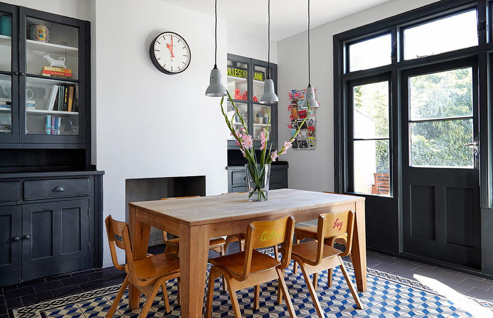 На фото: кухня-столовая среднего размера в скандинавском стиле с белыми стенами, стандартным камином и фасадом камина из бетона с