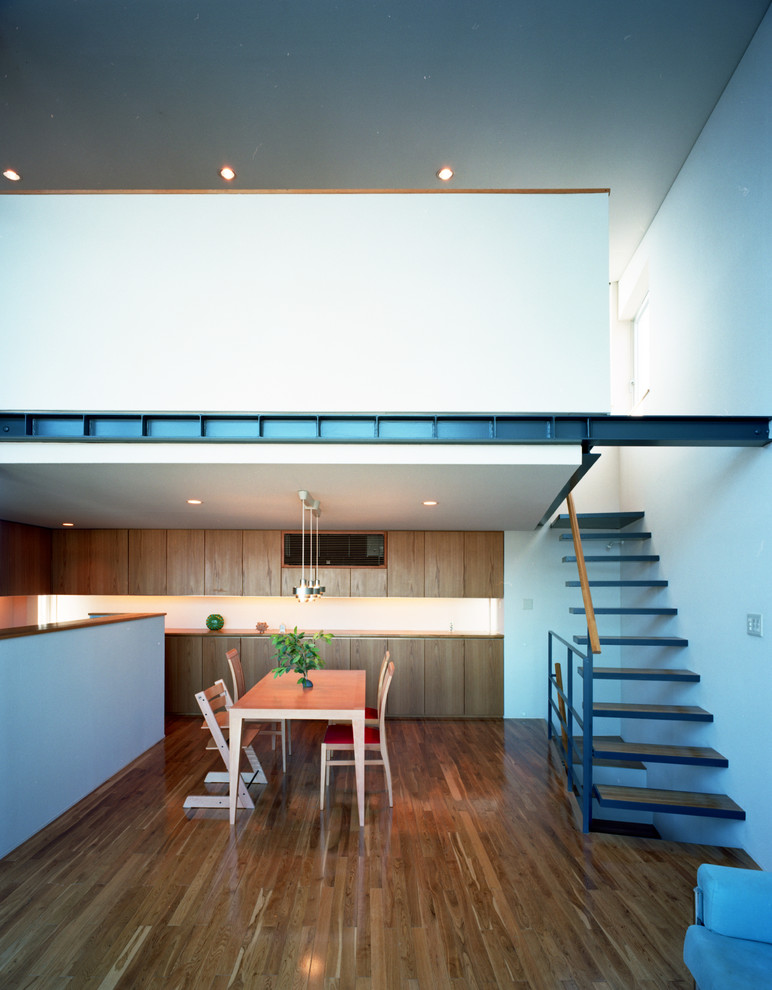 Идея дизайна: гостиная-столовая среднего размера в стиле модернизм с белыми стенами, паркетным полом среднего тона и коричневым полом без камина