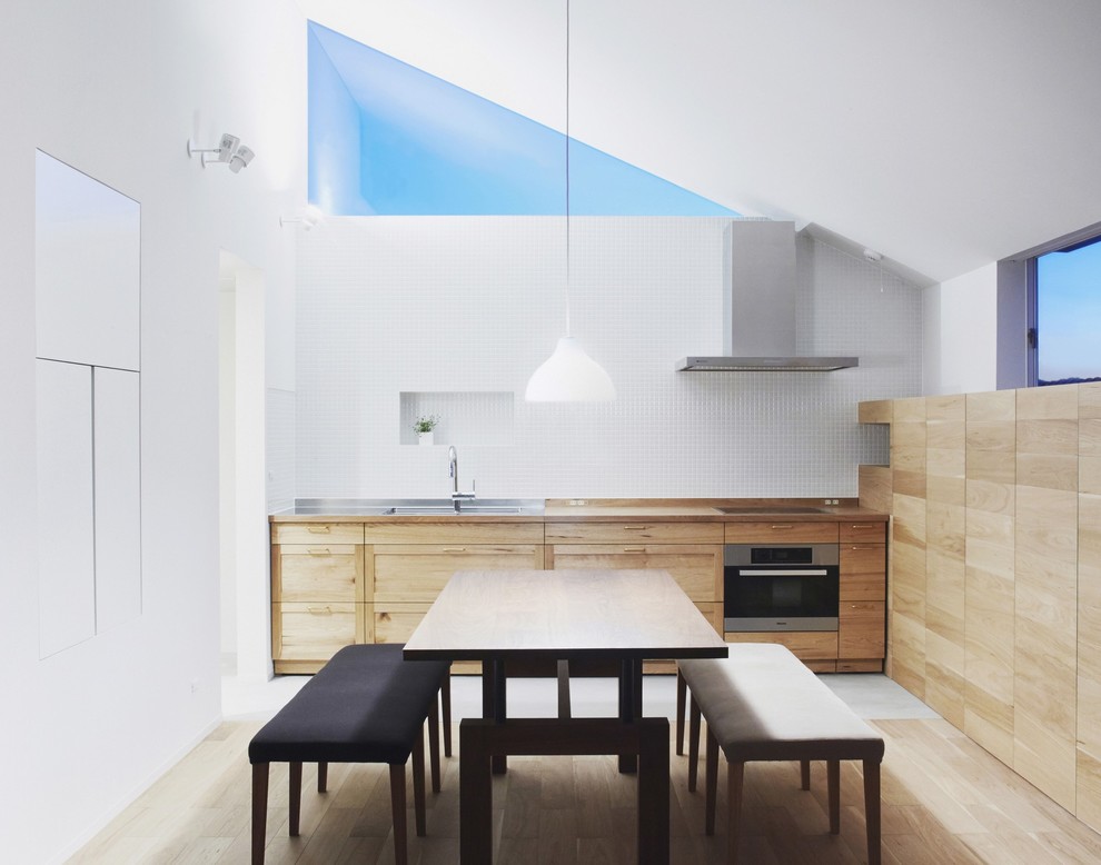 Cette photo montre une petite salle à manger moderne avec un mur blanc et parquet clair.