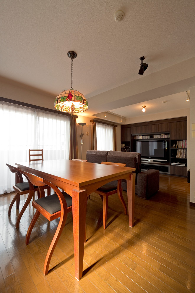 Photo of a contemporary dining room in Kobe with white walls and medium hardwood flooring.