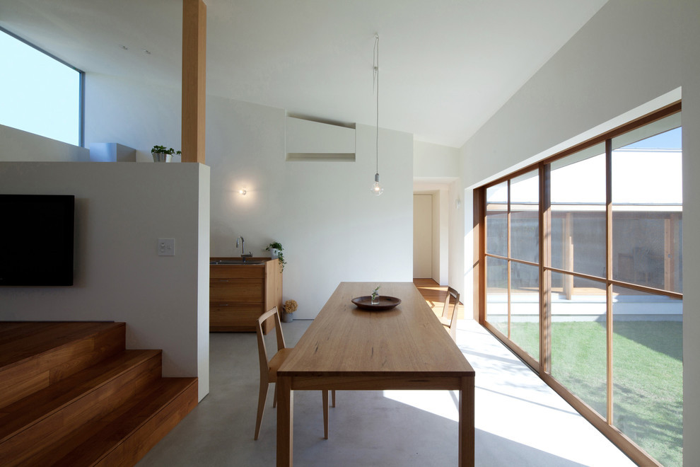 This is an example of a small modern open plan dining room in Nagoya with white walls and dark hardwood flooring.