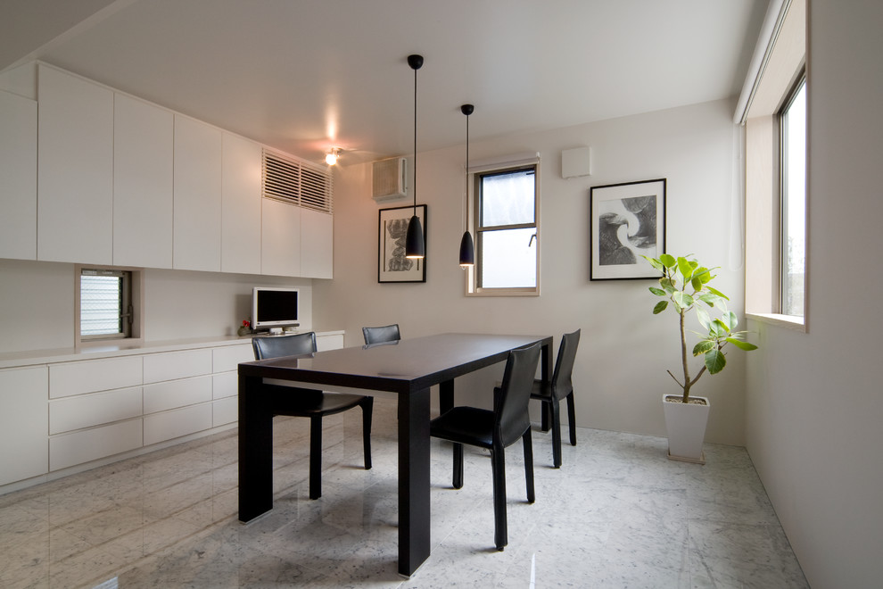 Immagine di una sala da pranzo minimal con pareti bianche, pavimento in marmo e pavimento grigio