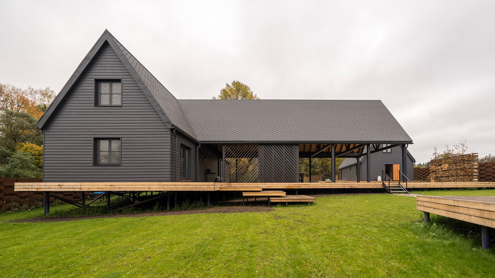 Стильный дизайн: двухэтажный, серый частный загородный дом в стиле кантри с двускатной крышей - последний тренд
