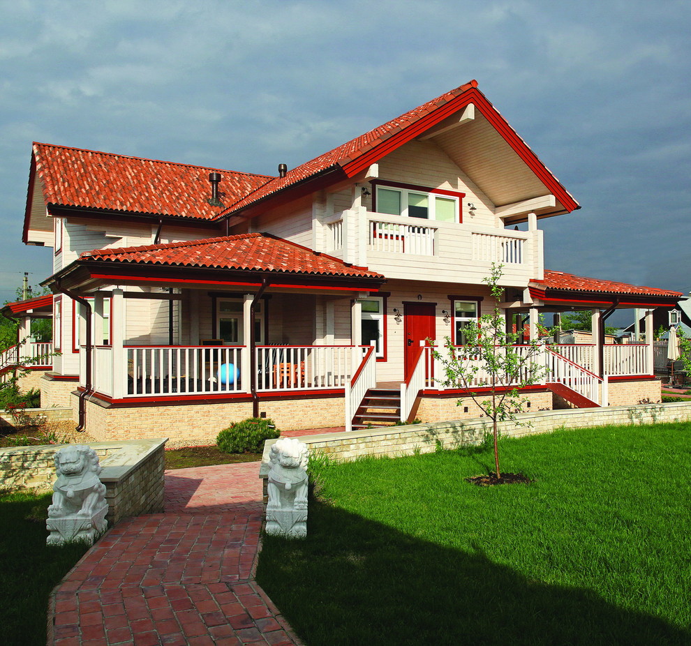 Ejemplo de fachada de casa blanca de estilo de casa de campo de tamaño medio de dos plantas con revestimiento de madera, tejado a dos aguas y tejado de teja de barro