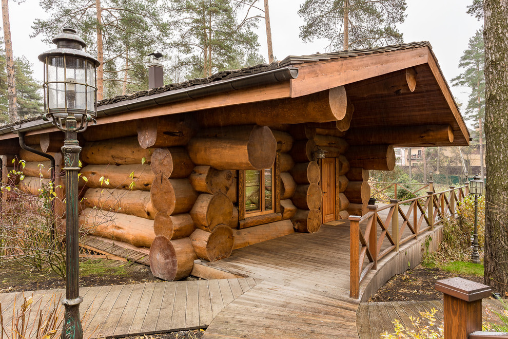 Medium sized and brown rustic bungalow detached house in Moscow with wood cladding and a pitched roof.