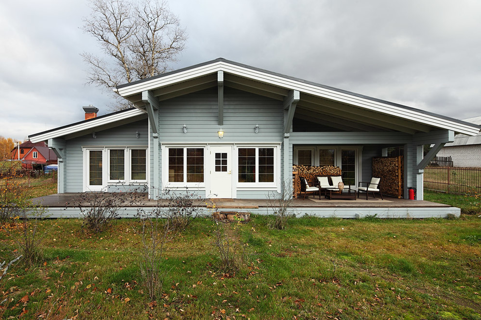 Пример оригинального дизайна: одноэтажный, деревянный, серый частный загородный дом среднего размера в скандинавском стиле с двускатной крышей и черепичной крышей
