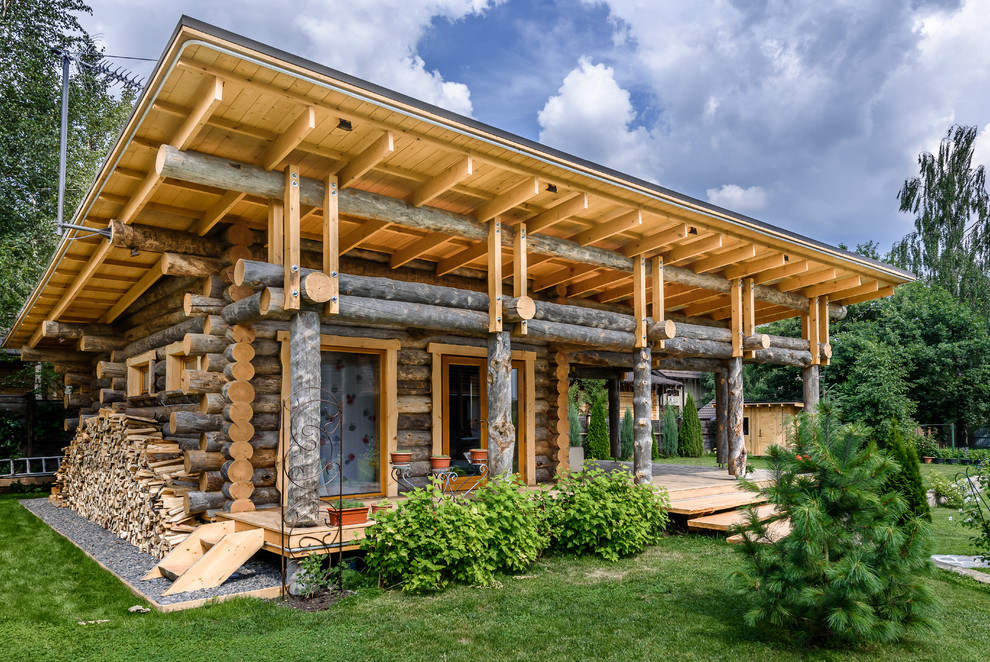 Пример оригинального дизайна: деревянный, одноэтажный, коричневый частный загородный дом в стиле рустика с односкатной крышей
