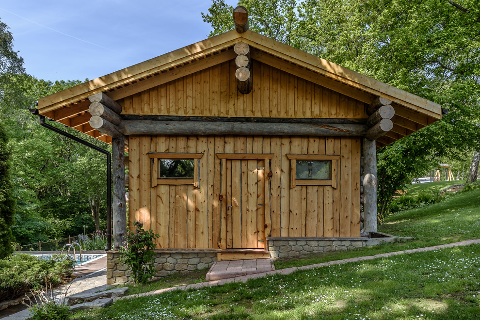 Пример оригинального дизайна: одноэтажный, деревянный, коричневый дом в стиле рустика с двускатной крышей