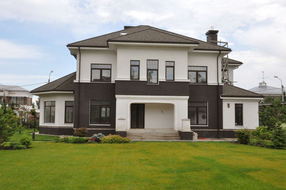 Großes, Zweistöckiges Klassisches Einfamilienhaus mit Mix-Fassade, schwarzer Fassadenfarbe, Mansardendach und Schindeldach in Moskau