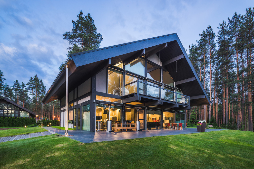 Стильный дизайн: большой, трехэтажный, серый дом в современном стиле с комбинированной облицовкой и двускатной крышей - последний тренд