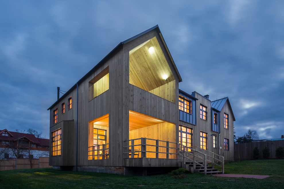 Diseño de fachada de casa marrón campestre grande de dos plantas con revestimiento de madera, tejado a doble faldón y tejado de metal