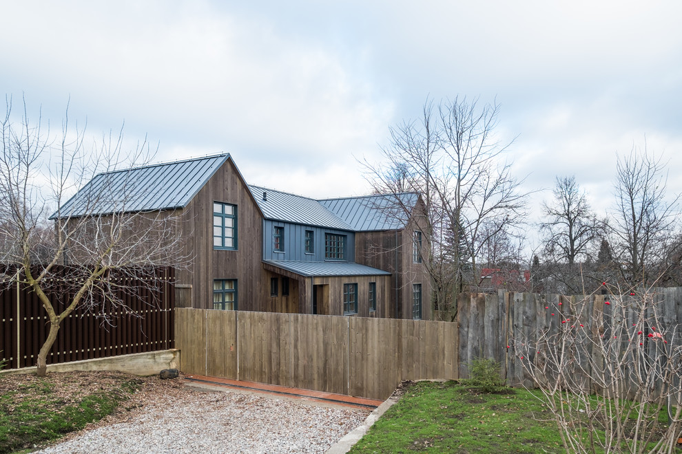 Idée de décoration pour une grande façade de maison marron champêtre en bois à un étage avec un toit de Gambrel et un toit en métal.