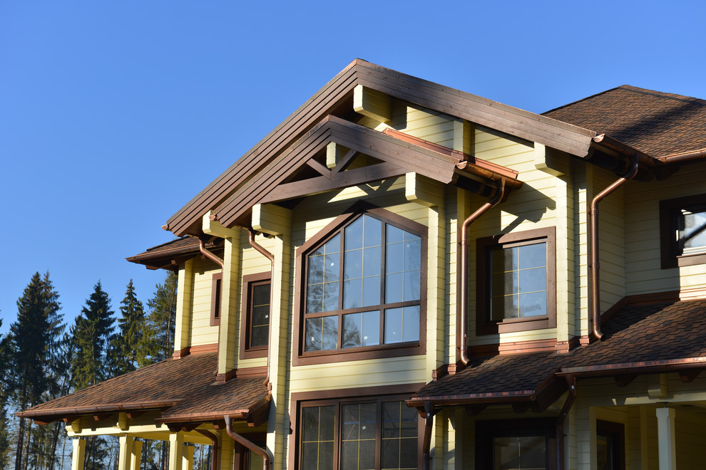 Diseño de fachada de casa beige grande de dos plantas con revestimiento de madera y tejado de teja de madera