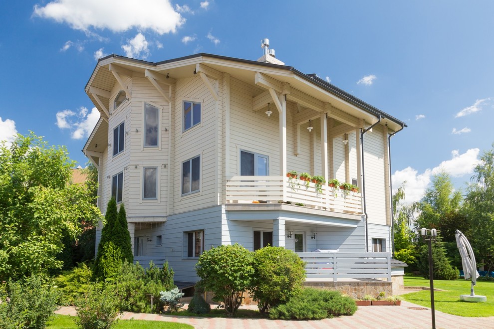 Стильный дизайн: трехэтажный, белый частный загородный дом в стиле кантри - последний тренд