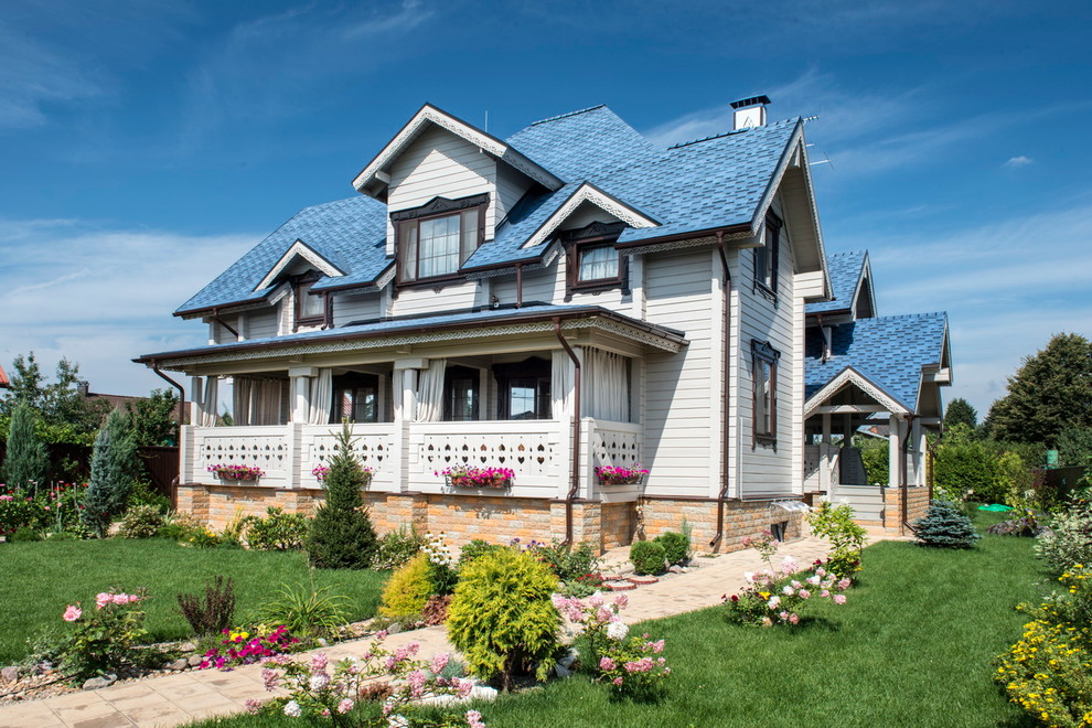 Imagen de fachada de casa blanca campestre de dos plantas con revestimiento de madera