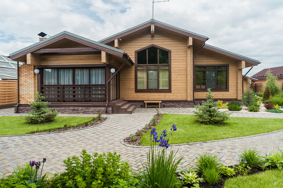 Стильный дизайн: деревянный, коричневый, одноэтажный частный загородный дом среднего размера в стиле кантри с двускатной крышей и крышей из гибкой черепицы - последний тренд
