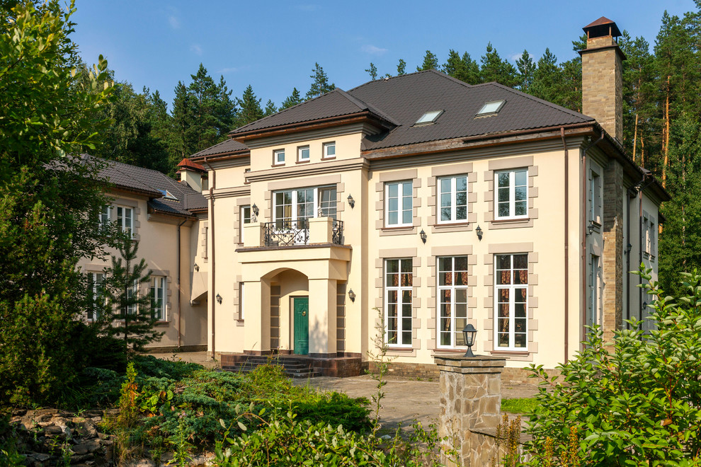 Diseño de fachada de casa beige clásica renovada de tres plantas con revestimiento de estuco, tejado a cuatro aguas y tejado de metal