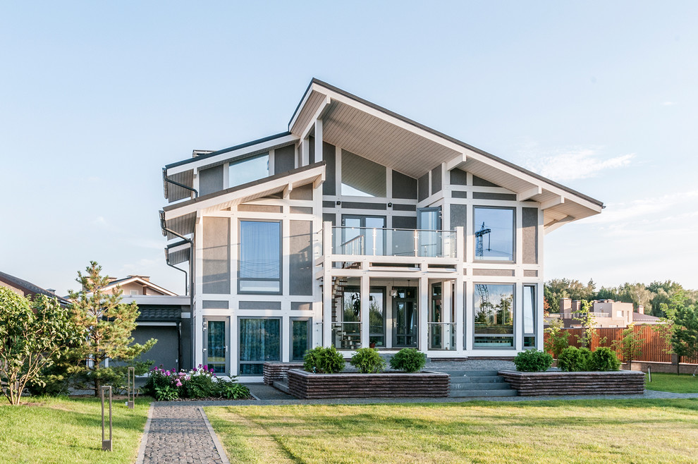 Свежая идея для дизайна: серый частный загородный дом в современном стиле с двускатной крышей и разными уровнями - отличное фото интерьера