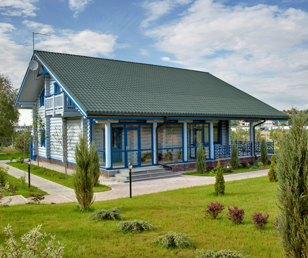 Foto della villa bianca country a due piani di medie dimensioni con rivestimento in legno e tetto a capanna