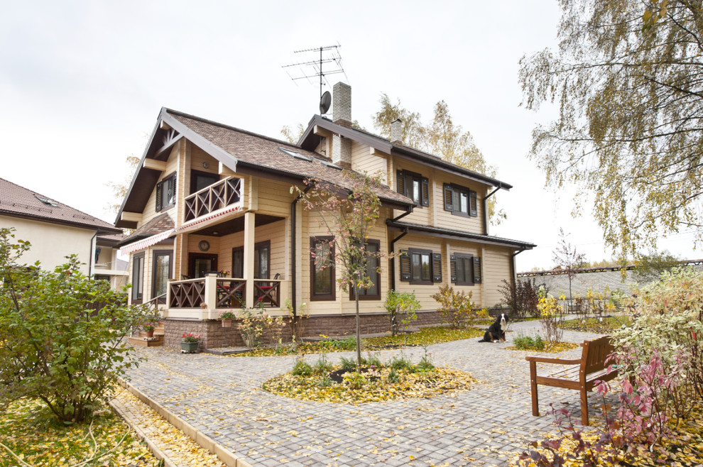 Esempio della villa beige contemporanea a due piani di medie dimensioni con rivestimento in legno e tetto a capanna
