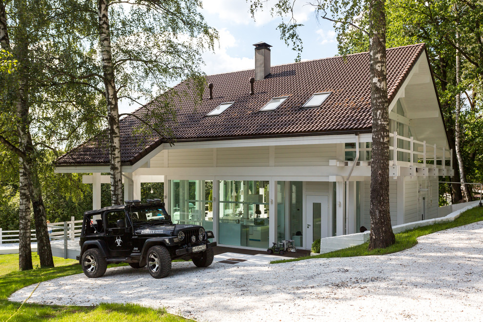 Esempio della facciata di una casa bianca scandinava a due piani con rivestimento in legno e tetto a capanna