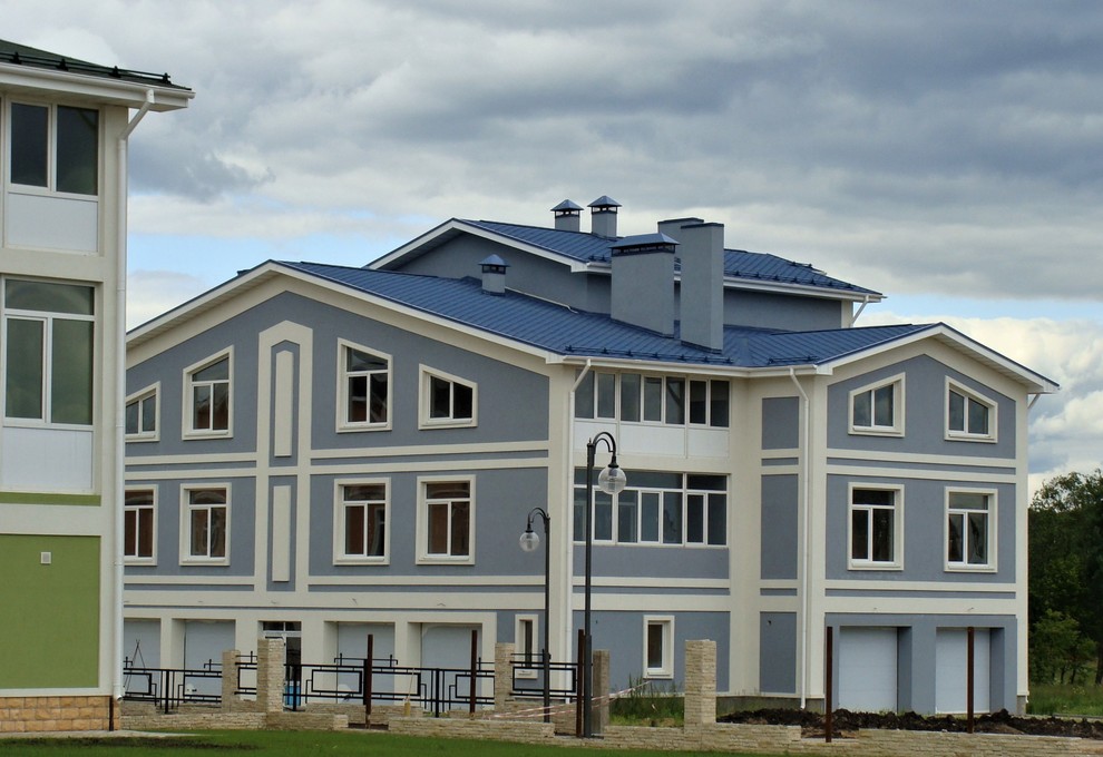 Esempio della facciata di un appartamento grande blu classico a piani sfalsati con rivestimento in stucco, tetto a mansarda e copertura a scandole