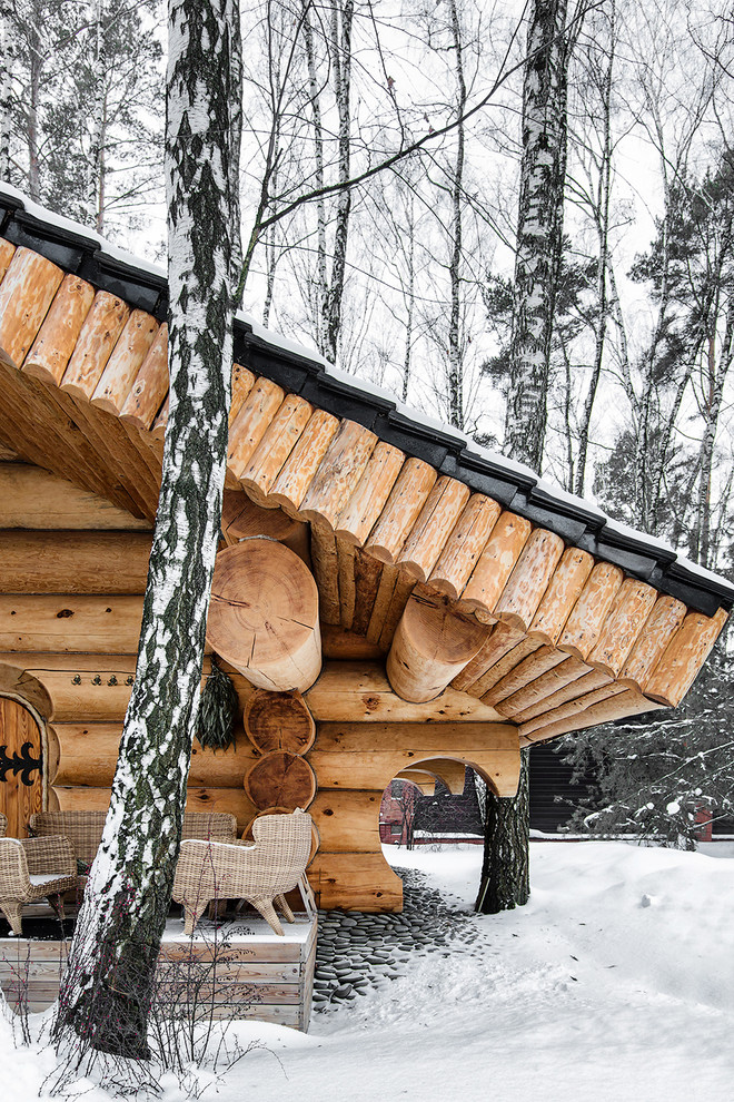 Идея дизайна: деревянный, коричневый дом в стиле рустика с двускатной крышей