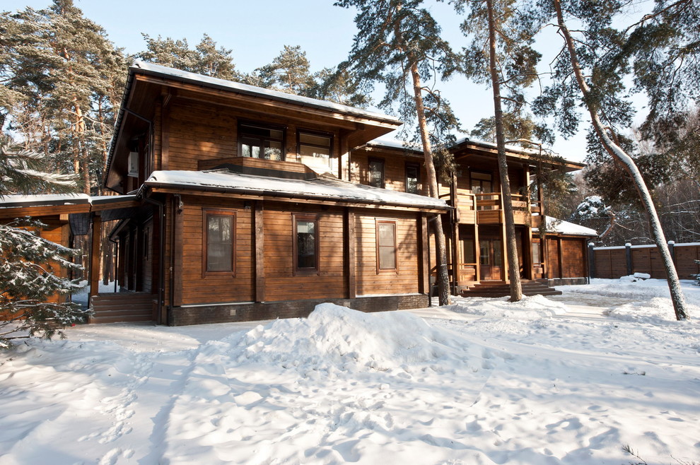 Exemple d'une grande façade de maison marron scandinave en bois à un étage avec un toit à quatre pans et un toit en shingle.