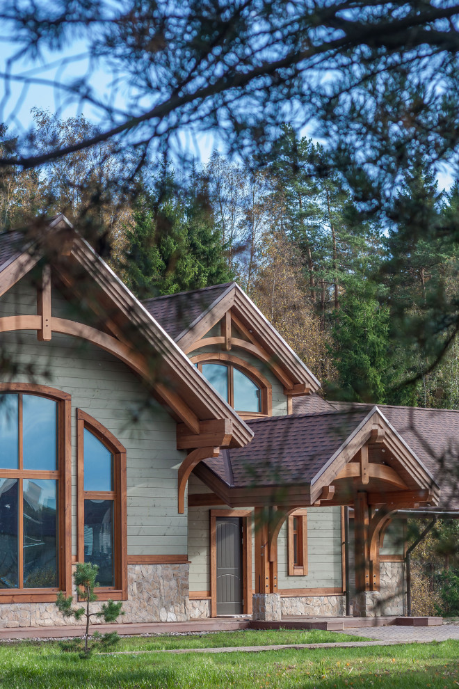 Réalisation d'une façade de maison verte champêtre en bois de taille moyenne et à un étage avec un toit de Gambrel et un toit en shingle.
