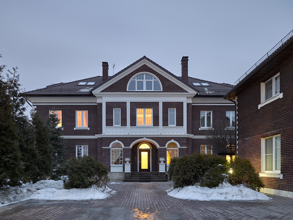 Modelo de fachada de casa marrón clásica renovada de tres plantas con revestimiento de ladrillo